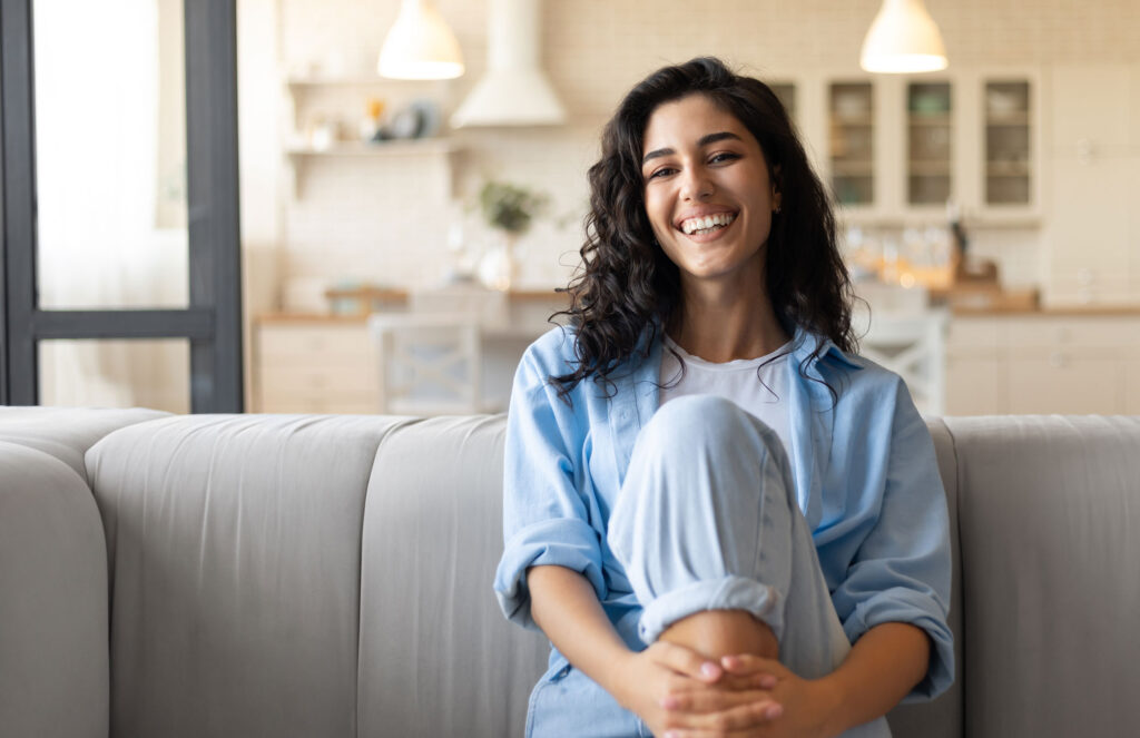 Smiling woman seated comfortably at home while practising body awareness