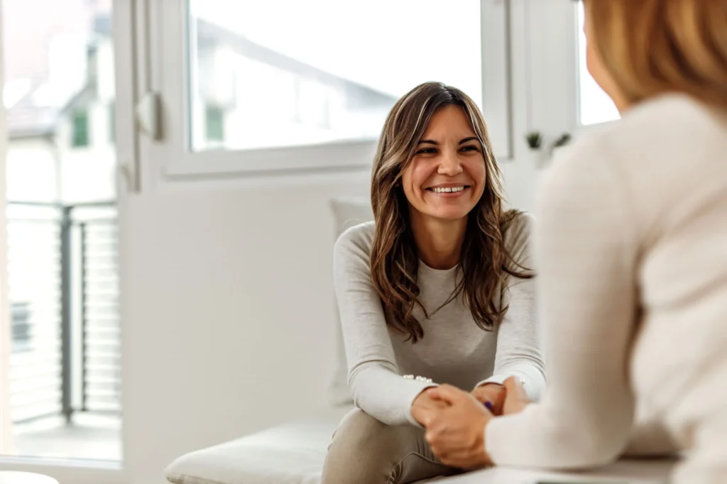 Smiling woman looking toward a wellbeing practitioner